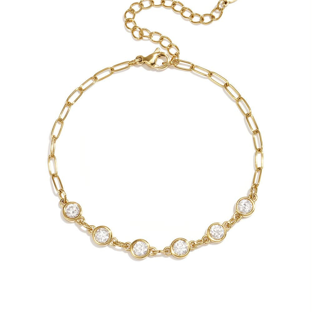 Gold paperclip chain bracelet with five clear round bezel-set stones.