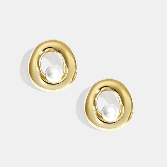 Sculptural open gold earrings with round pearl details.