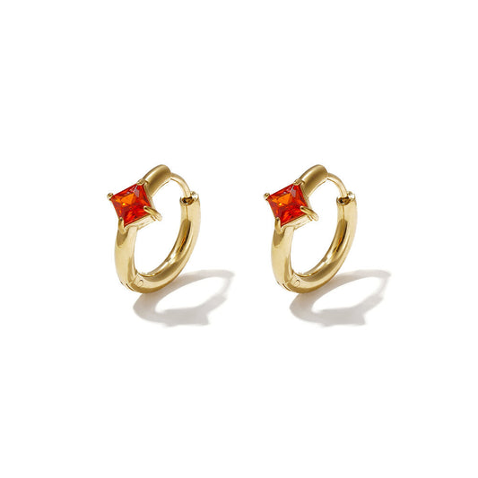 Gold huggie earrings with square burnt-orange zircon stones.
