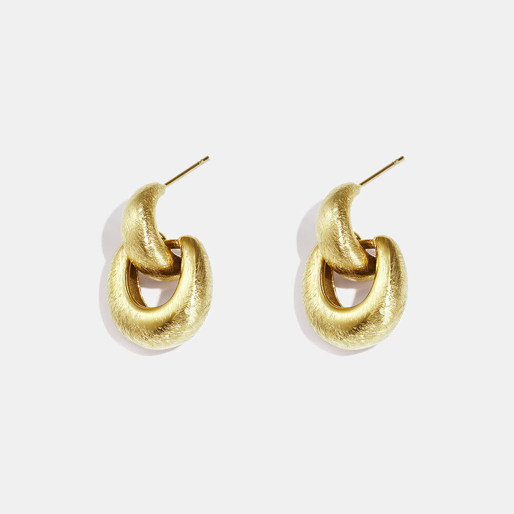 Gold interlocking hoop earrings with a softly brushed textured finish.