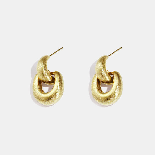 Gold interlocking hoop earrings with a softly brushed textured finish.