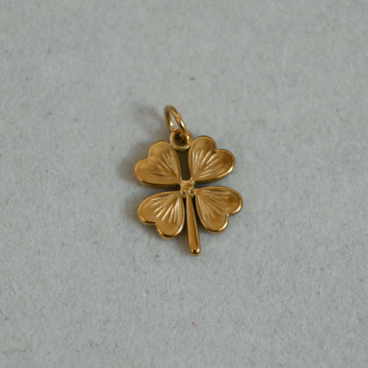 Gold horseshoe charm with small crystal details on a neutral background, designed for bracelets and necklaces.