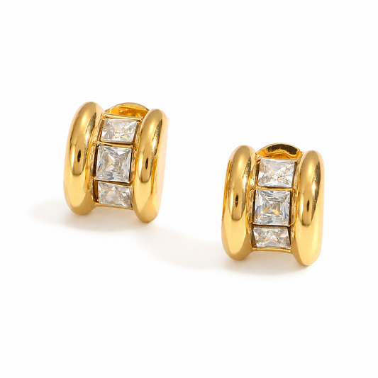 Small chunky gold studs earrings featuring three square-cut clear crystals set between polished gold edges.