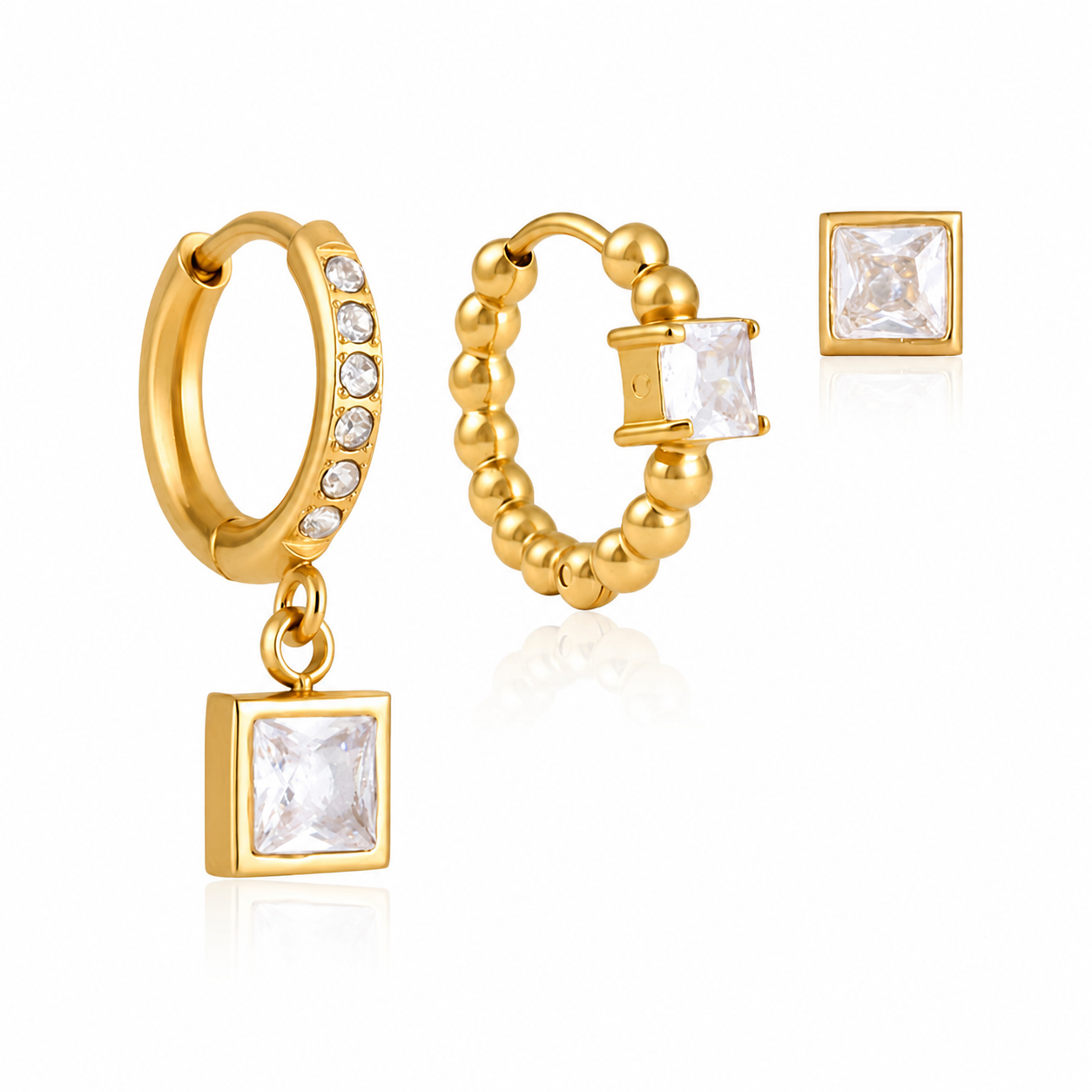 Gold three-piece single ear stack set featuring a crystal drop huggie, textured crystal hoop and square crystal stud