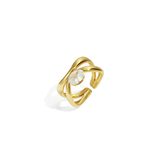 Open gold ring with crossing bands and a clear oval centre stone